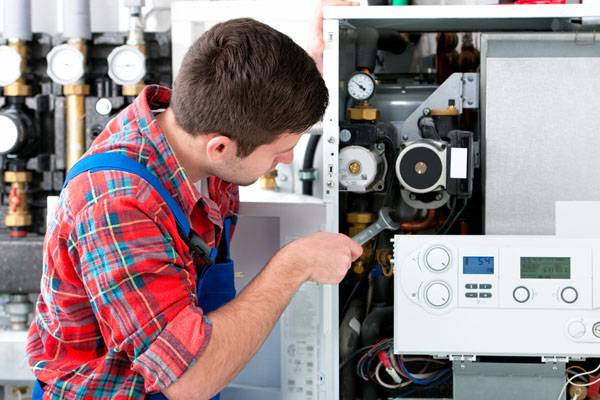 Heating technician repairing boiler controls in Los Angeles