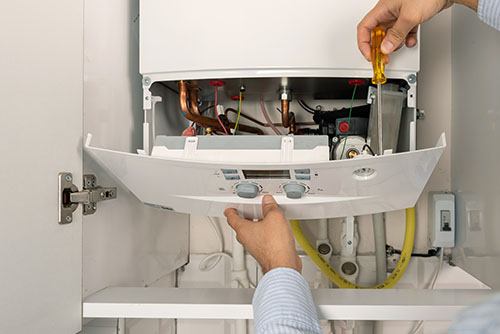 Heating technician repairing a residential boiler in Los Angeles