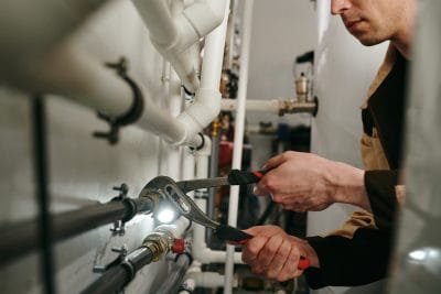 Technician inspecting commercial plumbing pipes in Los Angeles