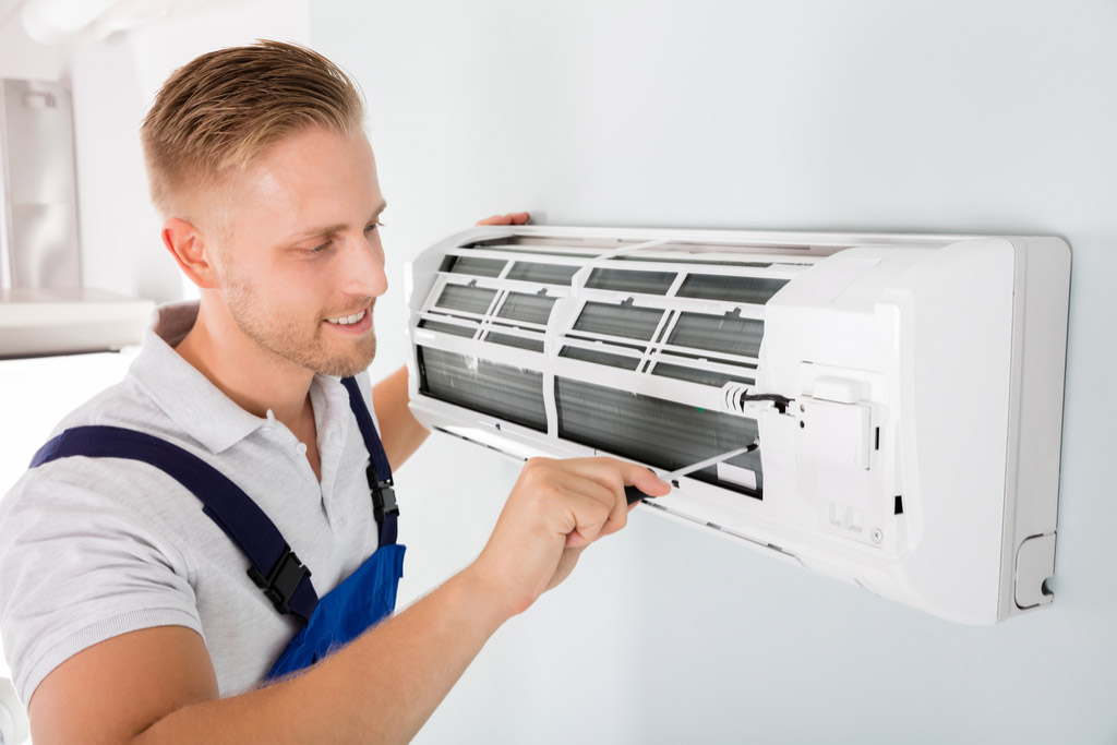 HVAC technician maintaining a ductless air conditioner in Los Angeles