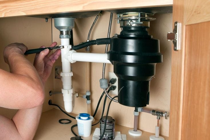 Plumber repairing a garbage disposal in Los Angeles