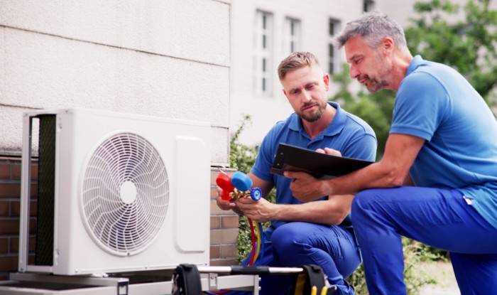 HVAC technicians installing an outdoor air conditioning unit in Los Angeles