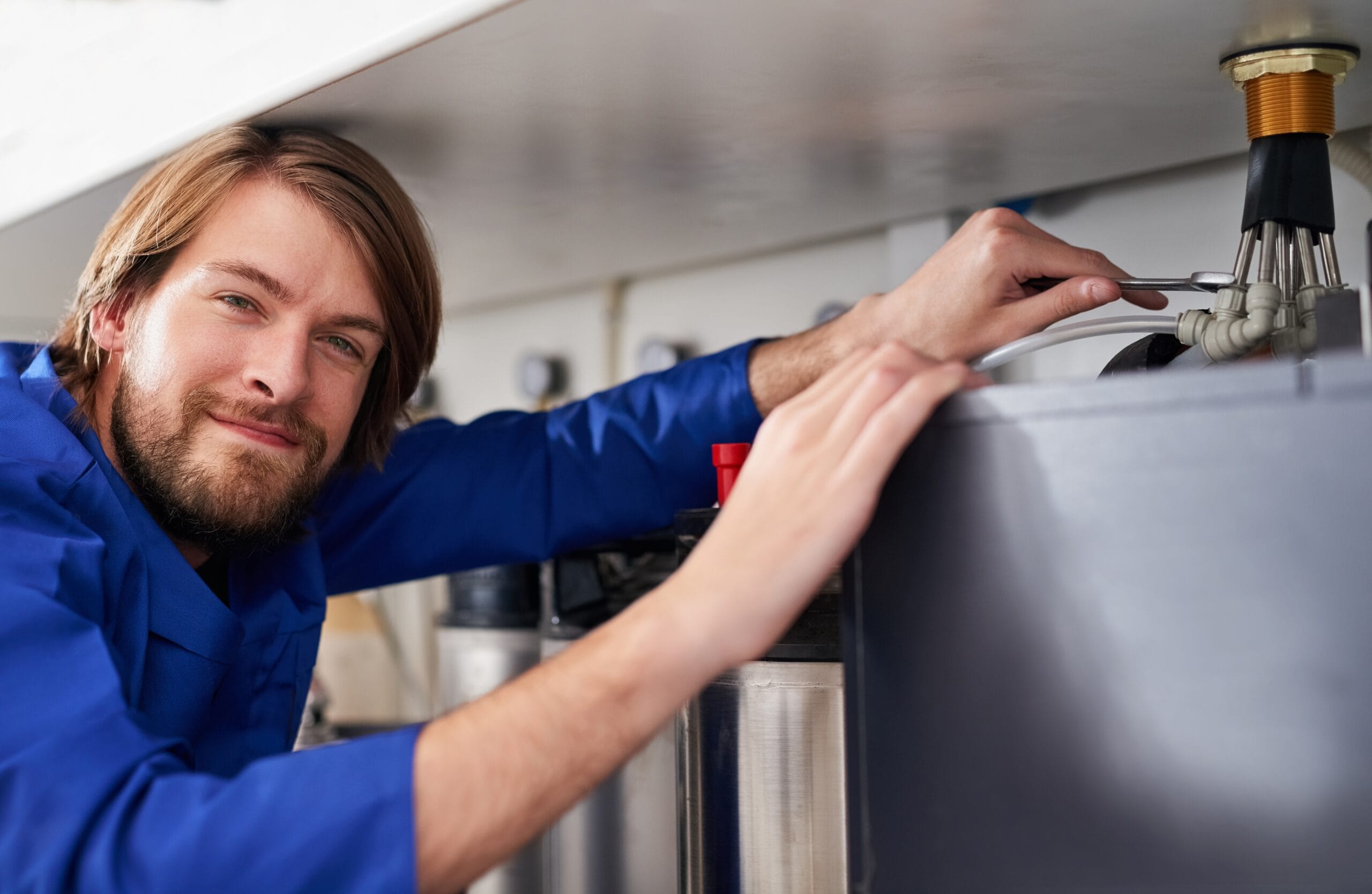 Technician servicing a residential water heater tank in Los Angeles
